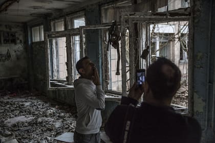 Turistas posan en una antigua escuela con máscaras de gas desechadas en Pripyat, Ucrania. El área de exclusión alrededor de Chernobyl está ganando seguidores como destino turístico debido a la serie emitida en 2019