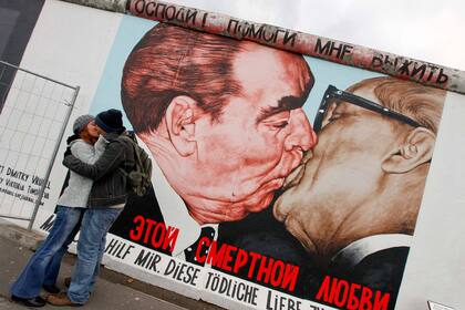 Turistas se besan frente al mural del artista ruso Dmitry Vrubel que muestra al exlíder soviético Leonid Brezhnev besando a su homólogo de Alemania Oriental Erich Honecker