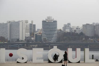 Turistas se sacan fotos con el logotipo de Seúl cerca del río Han en Seúl