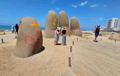 Turistas se sacan fotos con la escultura vandalizada