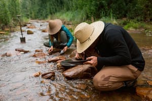 Turistas y gente de la zona practica la tradición de buscar pepitas de oro en el río.