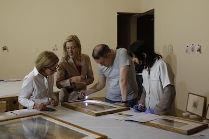 Los expertos locales revisan el estado de las obras antes de colgarlas