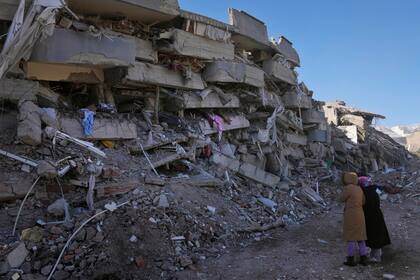 Mujeres de Turquía revisan su edificio destruido, en Kahramanmaras, al sur de Turquía (AP Photo/Hussein Malla)