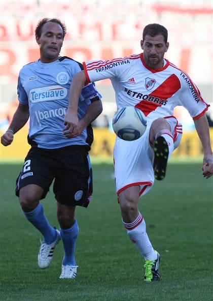 Gastón Turus persigue a Leandro Caruso durante el duelo por la promoción en el Monumental
