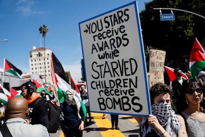 "Tus estrellas reciben premios mientras niños hambrientos reciben bombas", señalaba uno de los carteles de los participantes en la protesta en Hollywood