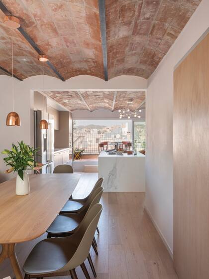 Ubicada en un paso amplio entre el living y la cocina que se abre a la terraza, un comedor de estilo escandinavo, con sillas de la firma danesa Menu.