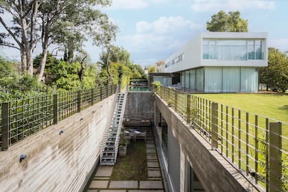 Ubicado estratégicamente abajo de la casa, el quincho de 200 metros cuadrados no implicó resignar más espacio que el del patio.