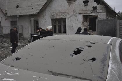 Los residentes locales observan sus hogares dañados en el ataque aéreo de Rusia en Zaporiyia, Ucrania, el viernes 29 de diciembre de 2023.