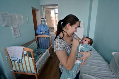 Una mujer junto a su bebé contagiado de Covid-19 en Ucrania