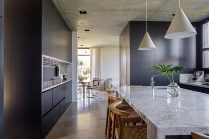 uebles laqueados, diseñados a medida por Estudio MMS. Mesadas de Dekton ‘Bergen’. Lámparas colgantes (Dimm) y banquetas (Marini).