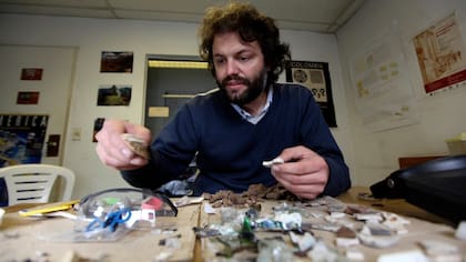 Ulises Camino, arqueólogo urbano, analiza objetos descartados en el ex corralón Vélez Sarsfield, en Floresta