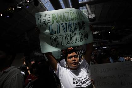 Un activista muestra un cartel que dice en portugués "Amazonia libre de petróleo", durante una protesta de movimientos sociales contra la exploración petrolera en la desembocadura del río Amazonas, durante las reuniones de Diálogos Amazónicos en el centro de convenciones Hangar en Belem, Brasil, el domingo 6 de agosto de 2023.
