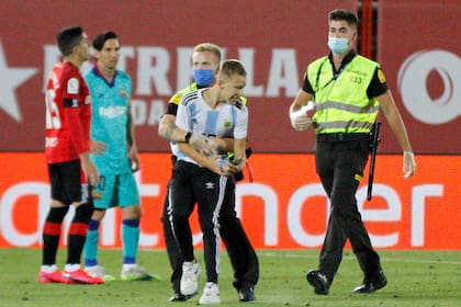 Desde lejos, Messi observa como el joven que llevaba la camiseta 10 de la selección argentina es detenido por los guardias