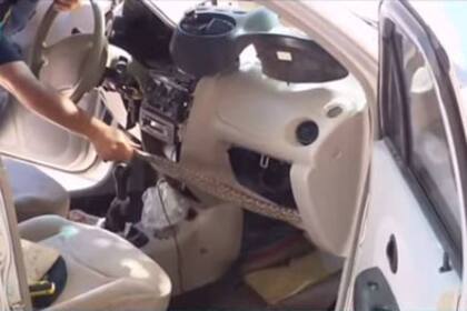 Un agente de la Patrulla Ambiental tira de la boa con la intención de sacarla del vehículo