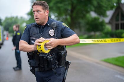 Un agente del Departamento de Policía de Brooklyn Park, Minnesota, establece un perímetro cerca del sitio donde se perpetró un tiroteo el 14 de junio de 2025. (Alex Kormann/Star Tribune vía AP)