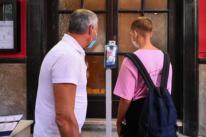 Un alumno se somete a un escáner de temperatura corporal cuando llega el 14 de septiembre de 2020 para el inicio del año escolar en la escuela secundaria técnica Luigi Einaudi en Roma, durante la pandemia de coronavirus