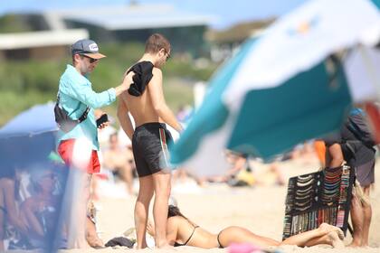 Un amigo ayudó a Furtado a limpiarse la arena del cuerpo