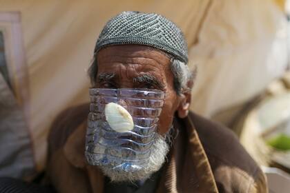 Un anciano gazatí cubrió su rostro con un envase plástico y una cebolla