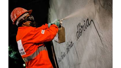 Un trabajador municipal elimina la escritura "doria" en referencia al alcalde de Sao Paulo, Joao Doria, etiquetado por un artista brasileño, conocido como Iaco, en la Avenida 23 de Mayo en San Pablo, Brasil