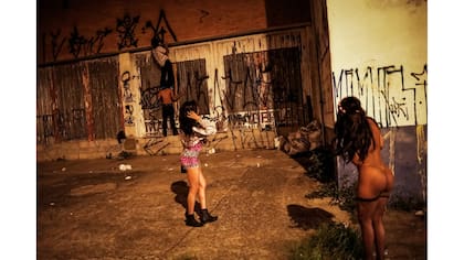 Transexuales miran a los "pichadores", mientras pintan sus firmas personales, llamadas "pichacao", en una pared de San Pablo