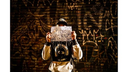 Un "pichador" sostiene un papel con su firma personal