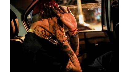 Un artista brasileño, conocido como Iaco, dentro del una patrulla policial después de que fue detenido por pintar en una pared