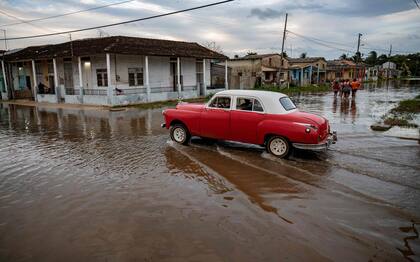 Un antiguo automóvil estadounidense atraviesa una zona inundada de Batabanó, Provincia Mayabeque, Cuba, el 28 de agosto de 2023, mientras la Tormenta Tropical Idalia se acerca a la punta occidental de la nación isleña.