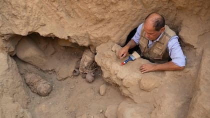 Un arqueólogo trabaja en una zona donde se hallaron los restos de dos niños envueltos en fardos.
