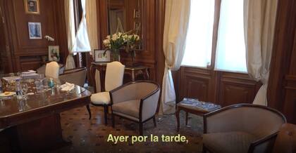 Un arreglo floral junto a la ventana del despacho y los vidrios rotos sobre la mesa principal