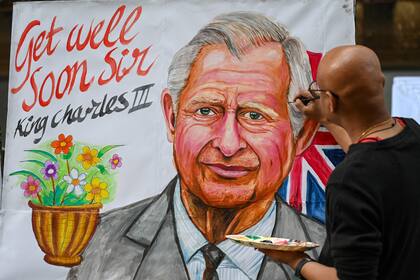 Un artista da los toques finales a una pintura del rey Carlos III de Gran Bretaña para desearle una pronta recuperación, frente a una escuela de arte en Bombay el 6 de febrero de 2024, tras el anuncio del Palacio de Buckingham sobre el diagnóstico de cáncer del monarca británico. 