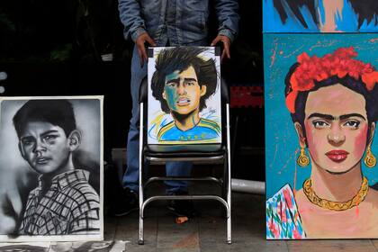 Un artita callejero muestra un pintura en honor a Diego Maradona en Bogotá, Colombia
