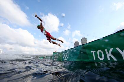 Un atleta compite en la etapa de natación del triatlón individual masculino en los Juegos Olímpicos de Verano de 2020, el lunes 26 de julio de 2021, en Tokio.