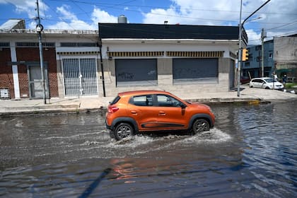 Un auto avanza entre calles anegadas en Lanús, tras el fuerte temporal que dejó barrios bajo agua