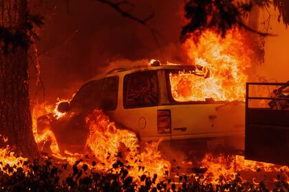 Un auto está envuelto en llamas mientras el Oak Fire arde en una zona no incorporada del condado de Mariposa, California, el sábado 23 de julio de 2022. 