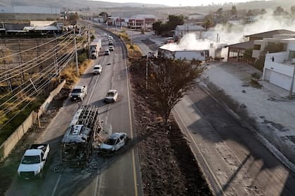 Un autobús y un automóvil incendiados incendiados en una carretera cerca de Acatlán de Juárez, Jalisco