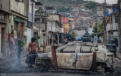 Un automóvil destruido en medio de una calle que fue escenario de los intensos tiroteos de este martes