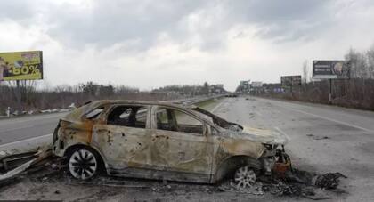 Un automóvil incendiado en la carretera donde mataron a Maksim y Ksenia.