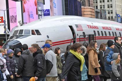 Las personas pasan al lado del avión que será llevado al aeropuerto JFK