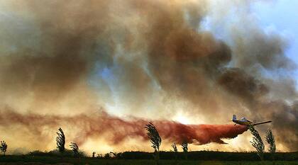 Un avión israelí intenta apagar las llamas causadas por un ataque de hezbollah, en el norte del país