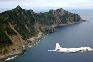 Un avión P-3C Orion de vigilancia de la Fuerza Marítima de Autodefensa de Japón vuela sobre las islas disputadas conocidas como Senkaku en Japón y Diaoyu en China, en el mar de China Oriental, el 13 de octubre de 2011
