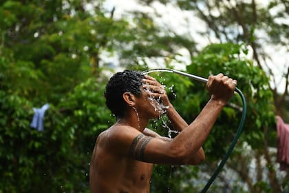 Un baño con una ducha improvisada en el barrio del Petare, Caracas