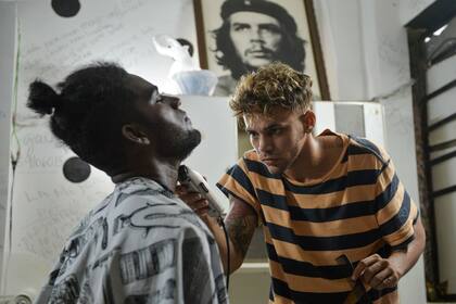 Un barbero corta la barba de un cliente en una barbería de La Habana, el 7 de agosto de 2019