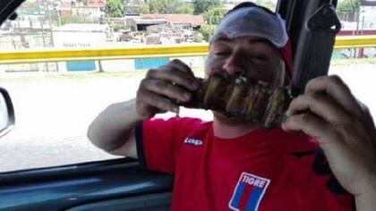 Un barrabrava de Tigre muestra a la cámara el asado que robaron camino a la cancha de Lanús