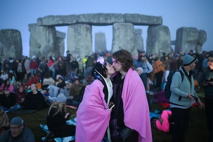 Un beso antes que salga el sol en Stonehenge, en Wiltshire, sur de Inglaterra, para celebrar el festival del Solsticio de Verano, el 21 de junio de 2023.