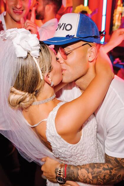 Un beso apasionado de los novios durante el carnaval carioca. Hubo vinchas de flores para ellas y gorras con leyendas divertidas para ellos.