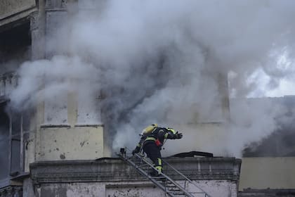 Un bombero gesticula mientras se prepara para entrar en un edificio en el lugar después de un ataque ruso en Kiev, Ucrania, jueves, 21 de marzo de 2024.