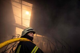 Un bombero lucha contra un incendio después de que los ataques rusos golpearan un almacén en los suburbios de Kiev el 24 de marzo de 2022.