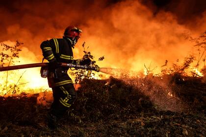 Un bombero lucha contra un incendio forestal cerca de Louchats en Gironde, suroeste de Francia, el 17 de julio de 2022. 