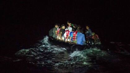 Un bote lleno de migrantes cruza a la isla griega de Lesbos por la noche, una de las rutas más utilizadas para ingresar a Europa por los migrantes afganos.