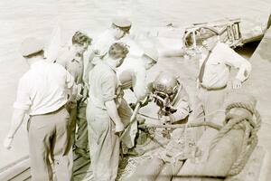 Un buzo se prepara para descender en las profundidades del río para tender los cables de amarre para recuperar el avión hundido el 31 de diciembre de 1957